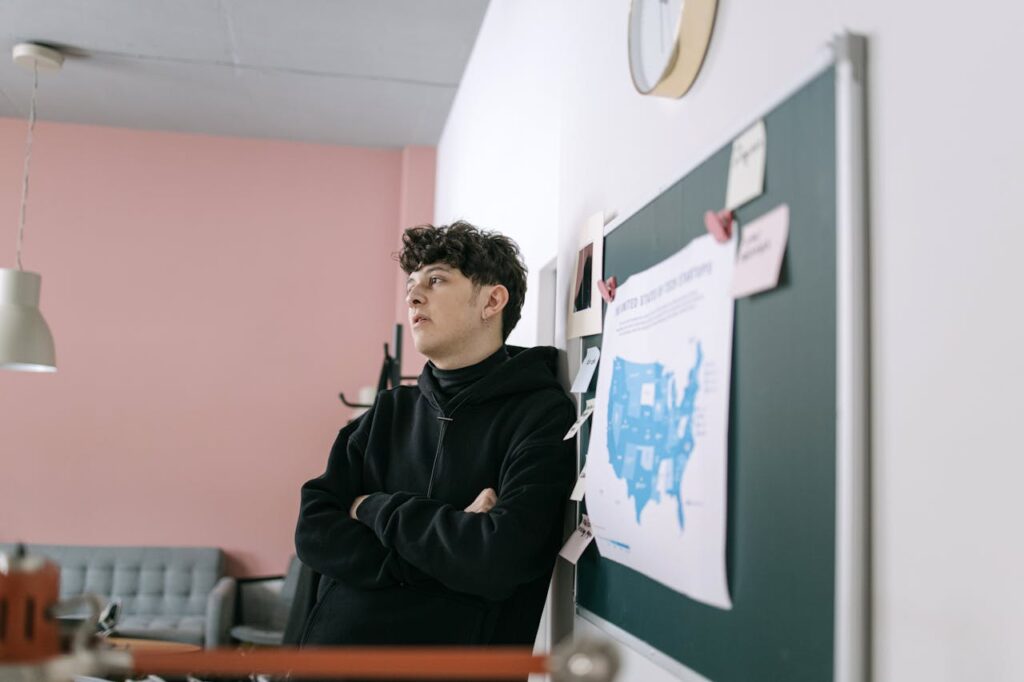 Man in Black Hoodie Sitting on Chair